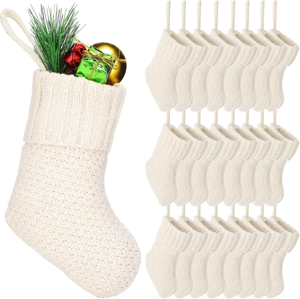 A large knit Christmas stocking adorned with greenery and ornaments, elegantly complemented by a festive Christmas ribbon, sits beside a set of twelve smaller identical stockings.