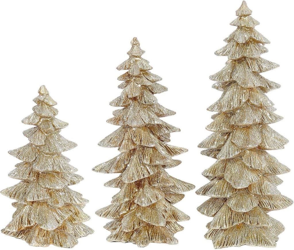 Three gold, glittery, decorative Christmas trees of varying heights stand side by side against a plain background, adding a touch of festive Christmas colors to the scene.