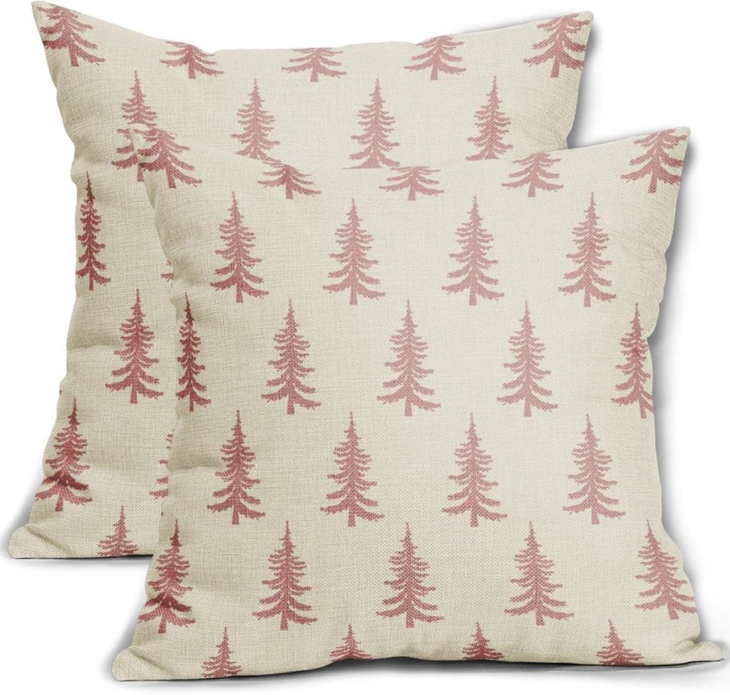 Two beige throw pillows adorned with a red tree pattern capture the essence of Christmas colors.