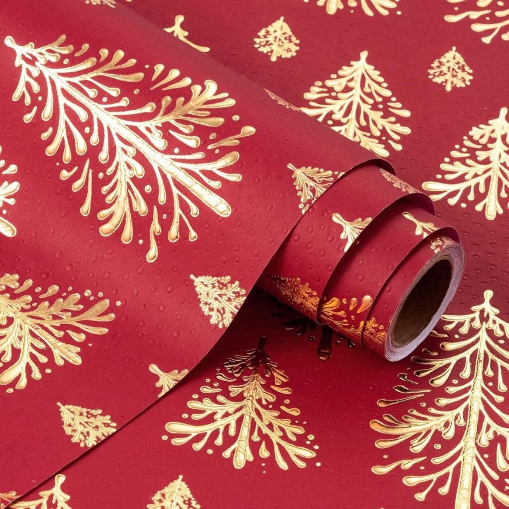 Red and gold wrapping paper with a Christmas tree pattern, partially unrolled, waiting for you to master how to tie a bow and add the perfect finishing touch.