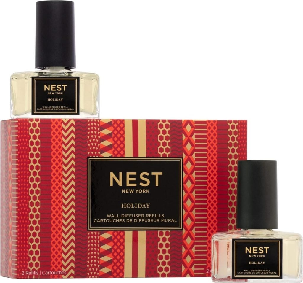 Nest New York Holiday wall diffuser refills come in a decorative red and orange patterned box, elegantly packaged with two clear bottles. Don't miss out on this stylish aroma upgrade—perfect for Black Friday shopping!