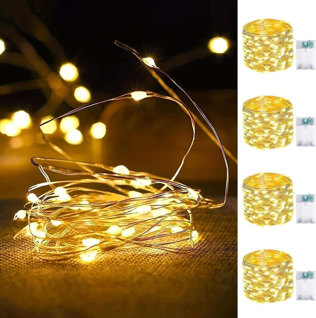 A tangled string of yellow fairy lights on the left, with four rolls of similar lights and battery packs to the right.