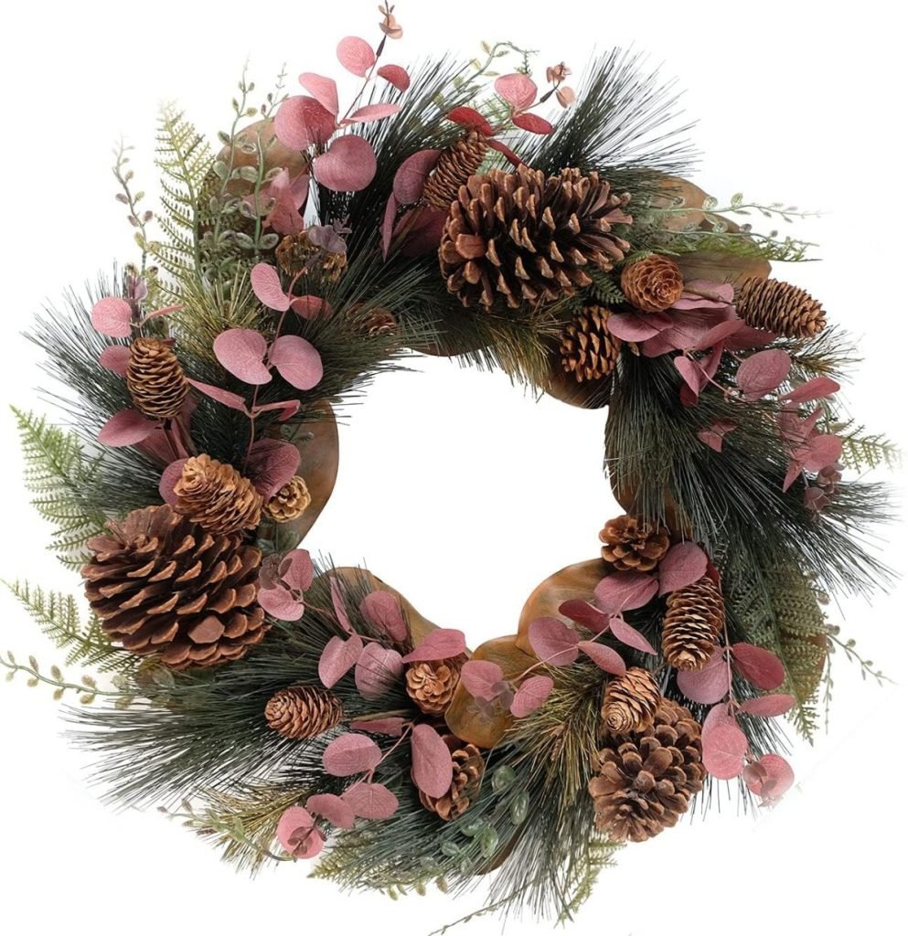 A Christmas wreath crafted from pinecones, pink eucalyptus leaves, and lush green foliage arranged in a circular design.