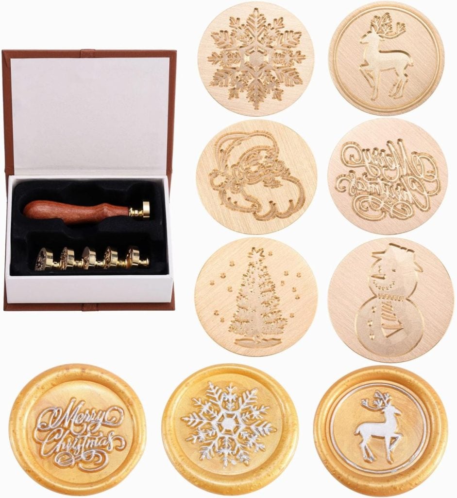 A set of wooden stamps with holiday designs, such as a snowflake, reindeer, Santa, tree, and snowman, perfect for adding charm to your gift wrapping. Each stamp leaves a beautiful impression in gold wax, making every present feel extra special.