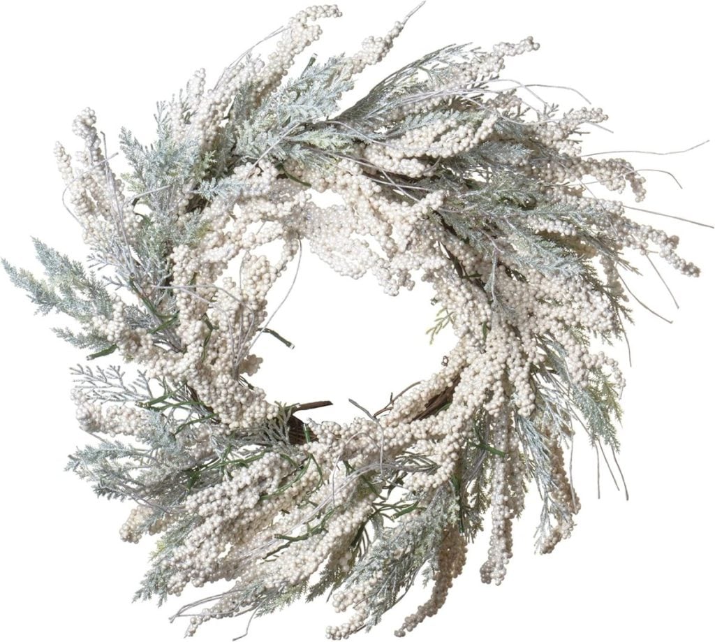 A Christmas wreath featuring frosted branches and white berry clusters, intricately arranged in a circular shape.