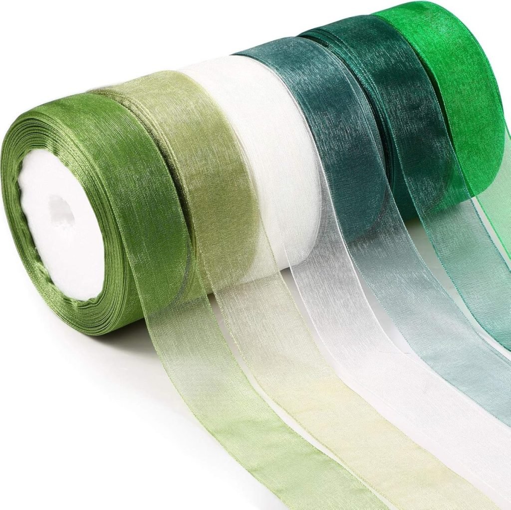 Five rolls of sheer, glossy ribbon in various shades of green and white are displayed in a row, perfect for elegant gift wrapping.