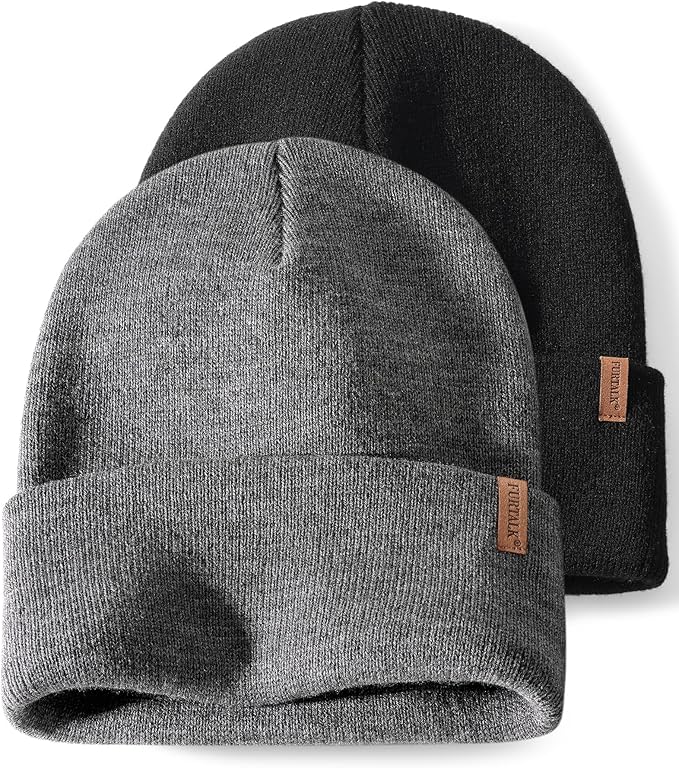 Two knit beanie hats, one gray and one black, with folded brims and small brown fabric tags on the side—perfect for keeping cozy on Christmas morning.