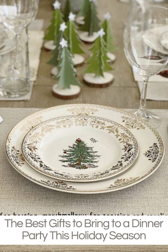 Elegant holiday-themed table setting with plates featuring a Christmas tree design, surrounded by glasses and small decorative trees. Text overlay: "The Best Gifts to Bring to a Dinner Party This Holiday Season.