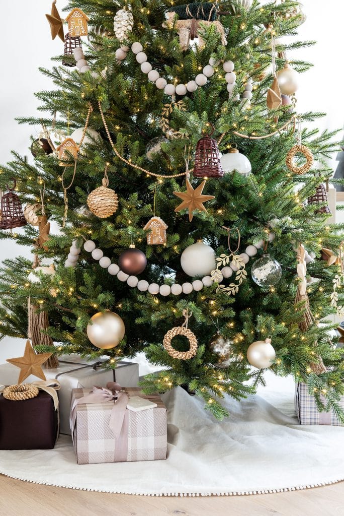 A Christmas tree adorned with stars and balls stands majestically, surrounded by immaculately gift-wrapped presents nestled underneath.