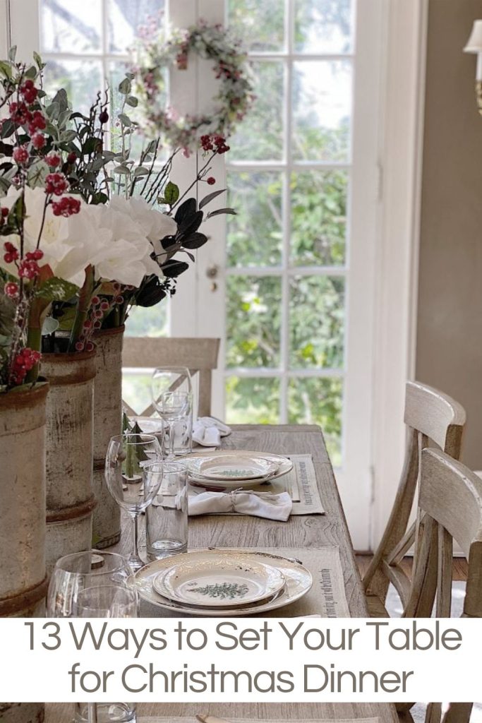 A Christmas table setting with floral centerpieces, glassware, and plates on a wooden table, near large windows. Text reads "13 Ways to Set Your Table for Christmas Dinner.