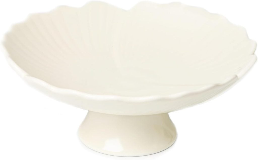 White scalloped-edge ceramic pedestal bowl on a plain background.