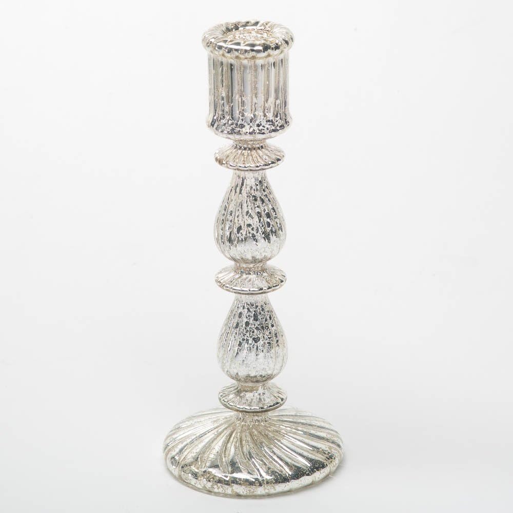 A silver-toned, intricately designed candle holder featuring a fluted top and a round, textured base.