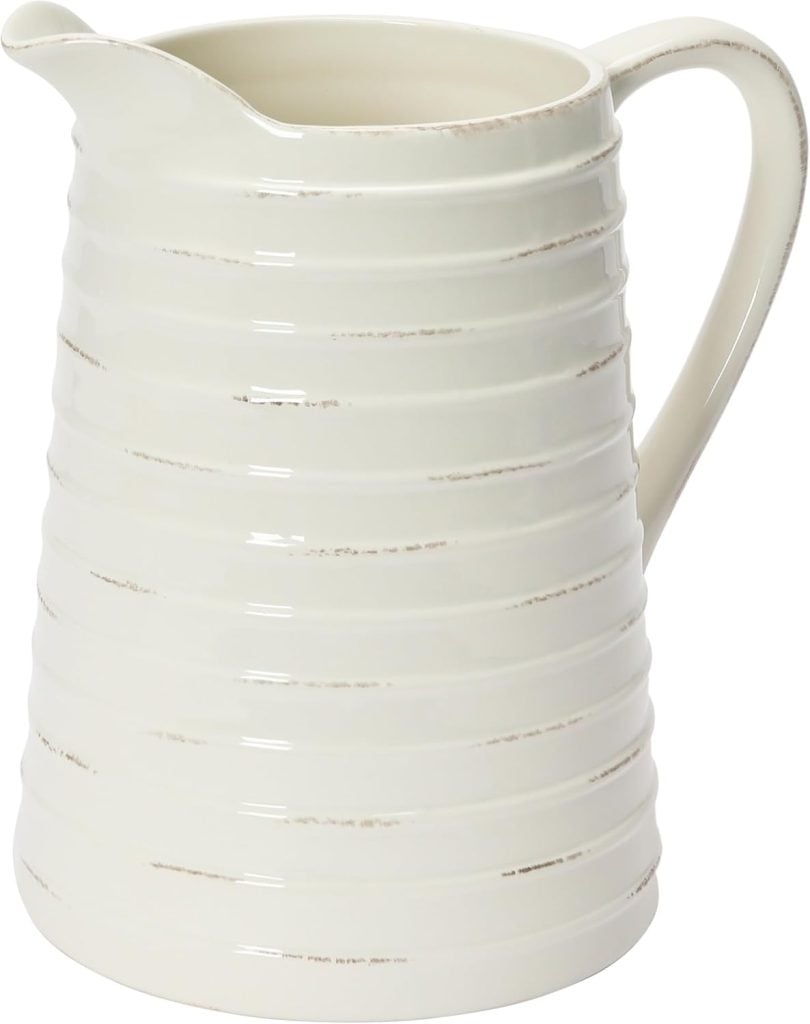 A white ceramic pitcher with a ribbed texture and a handle, perfect for serving cream or syrup on Christmas morning breakfast, shown against a plain background.