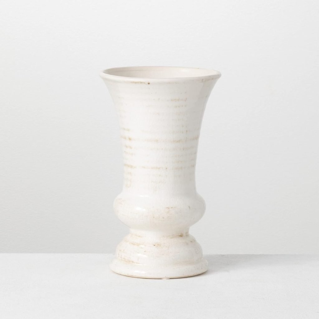 A tall, white ceramic vase with a flared top and bulbous base, set against a plain white background.