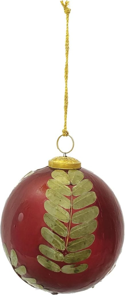 Red Christmas ornament with gold leaf design and a gold string for hanging.