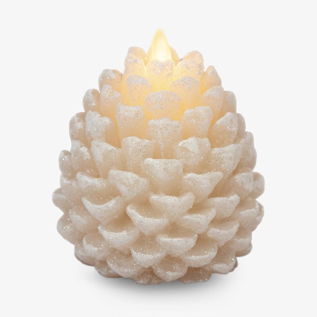 A candle shaped like a pinecone with a lit flame, featuring a textured, glittery white surface.