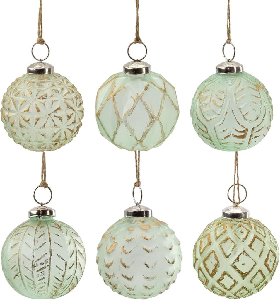 Six mint green glass ornaments with gold patterns hanging on strings.