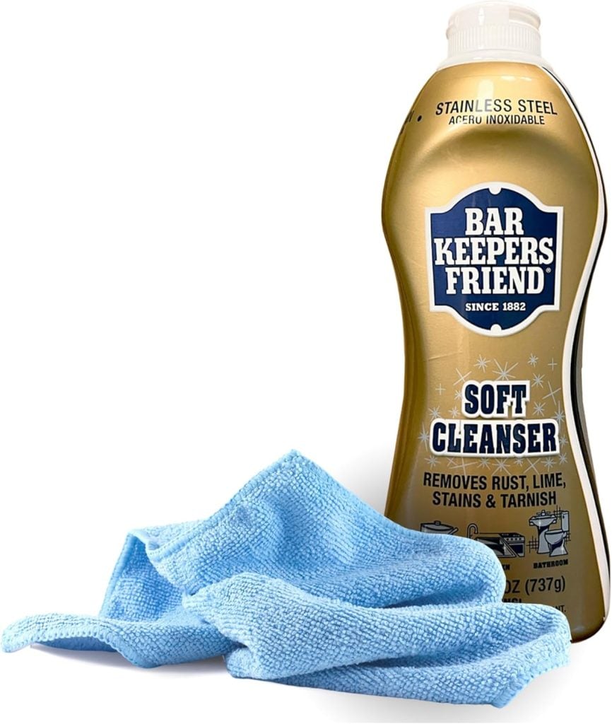 A bottle of Bar Keepers Friend Soft Cleanser stands next to a folded blue microfiber cloth, ready to help you create spotless surfaces for your table setting ideas.