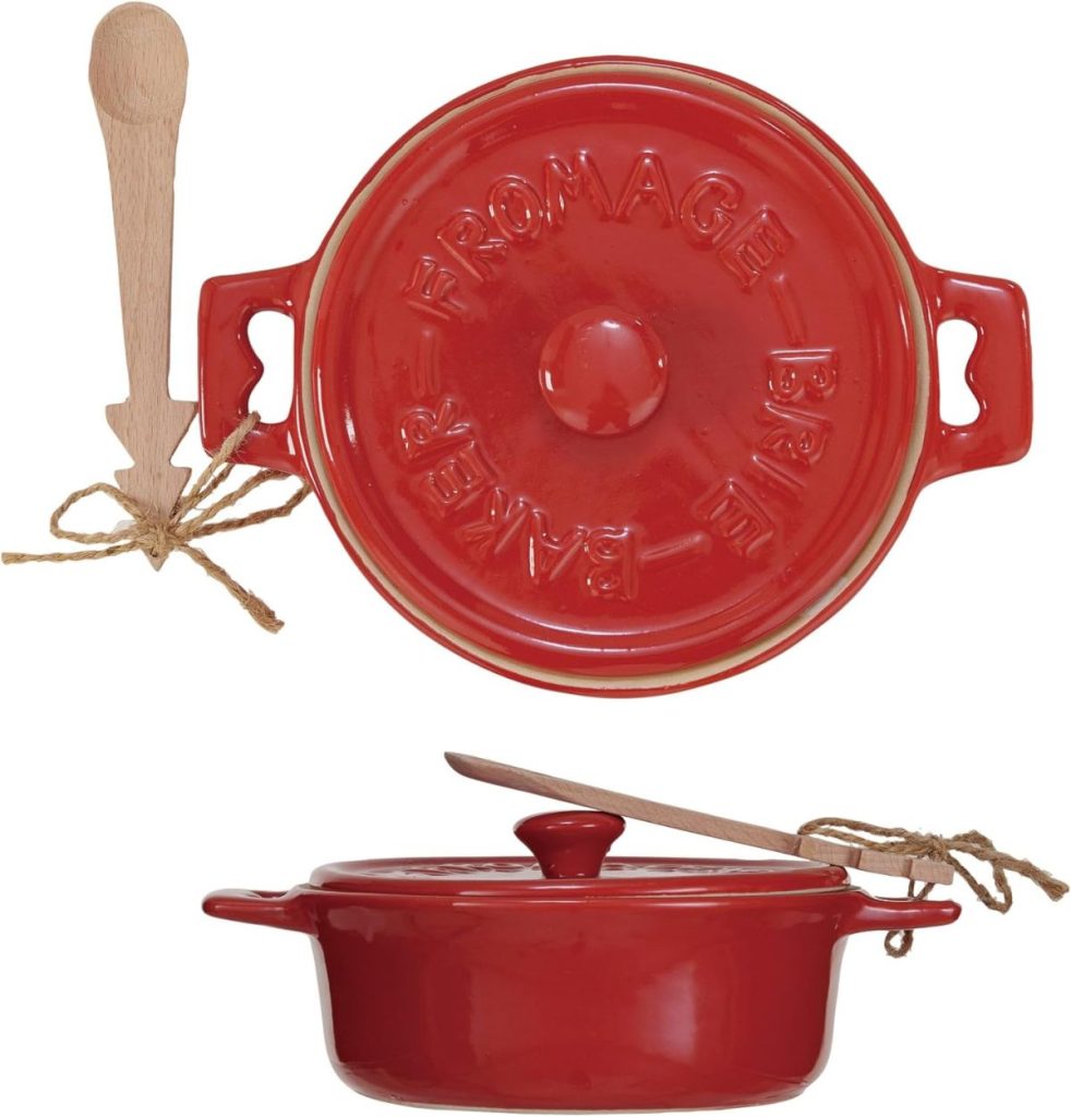 Red ceramic baking dish with lid labeled "FROMAGE BRIE BAKER," shown from top and side view, accompanied by a wooden spreader tied with twine—perfect for serving baked brie at your next Christmas party.