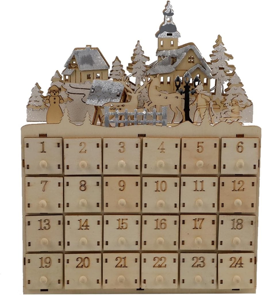 Wooden advent calendar with numbered drawers, perfect for organizing and displaying Christmas cards. It features a snowy village scene on top, complete with houses, trees, a church, and a snowman.