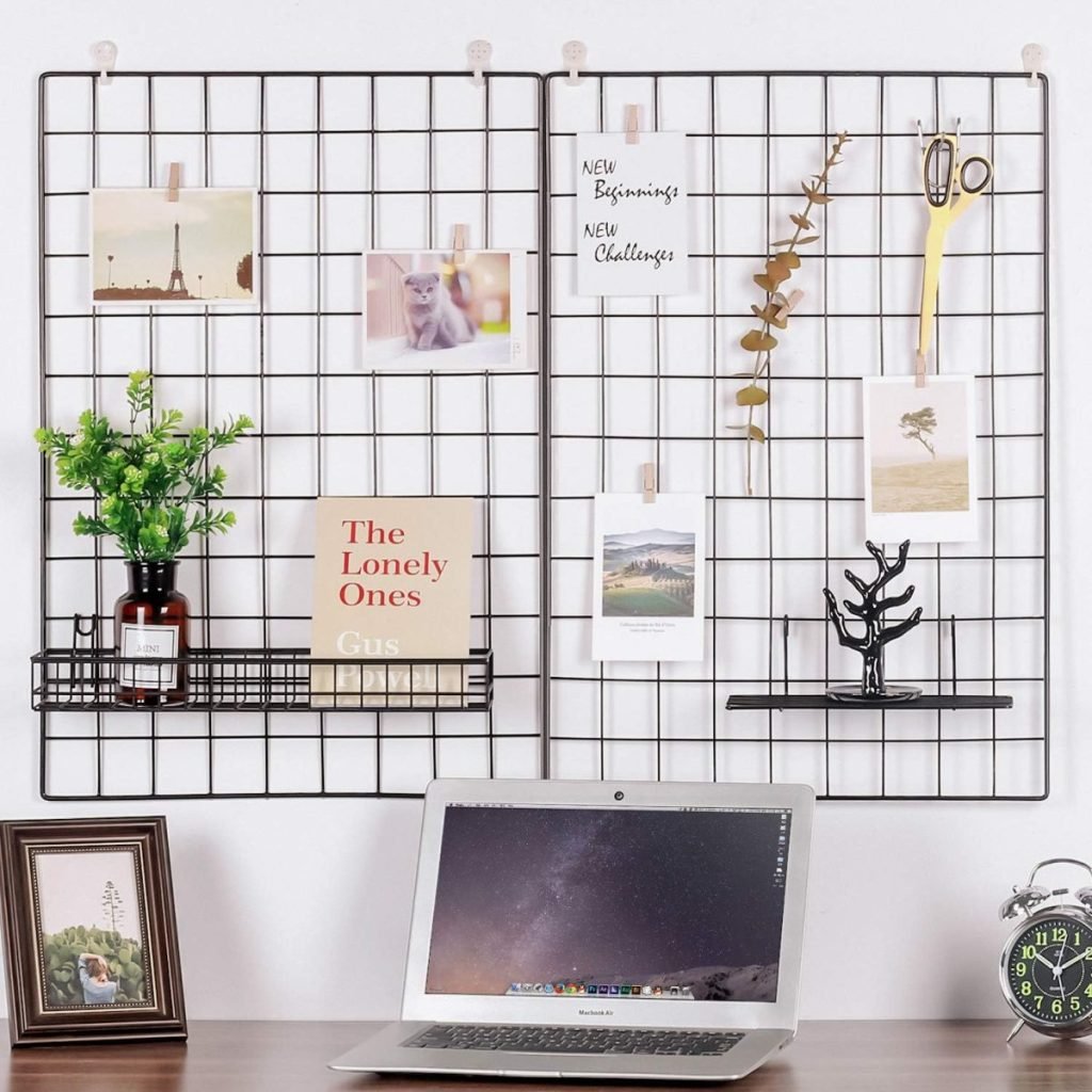 Wall-mounted wire grids showcase various items, including a book, photo prints, scissors, and a plant. Display Christmas cards alongside the laptop on the desk for a festive touch, with a clock and framed picture completing the cozy scene.