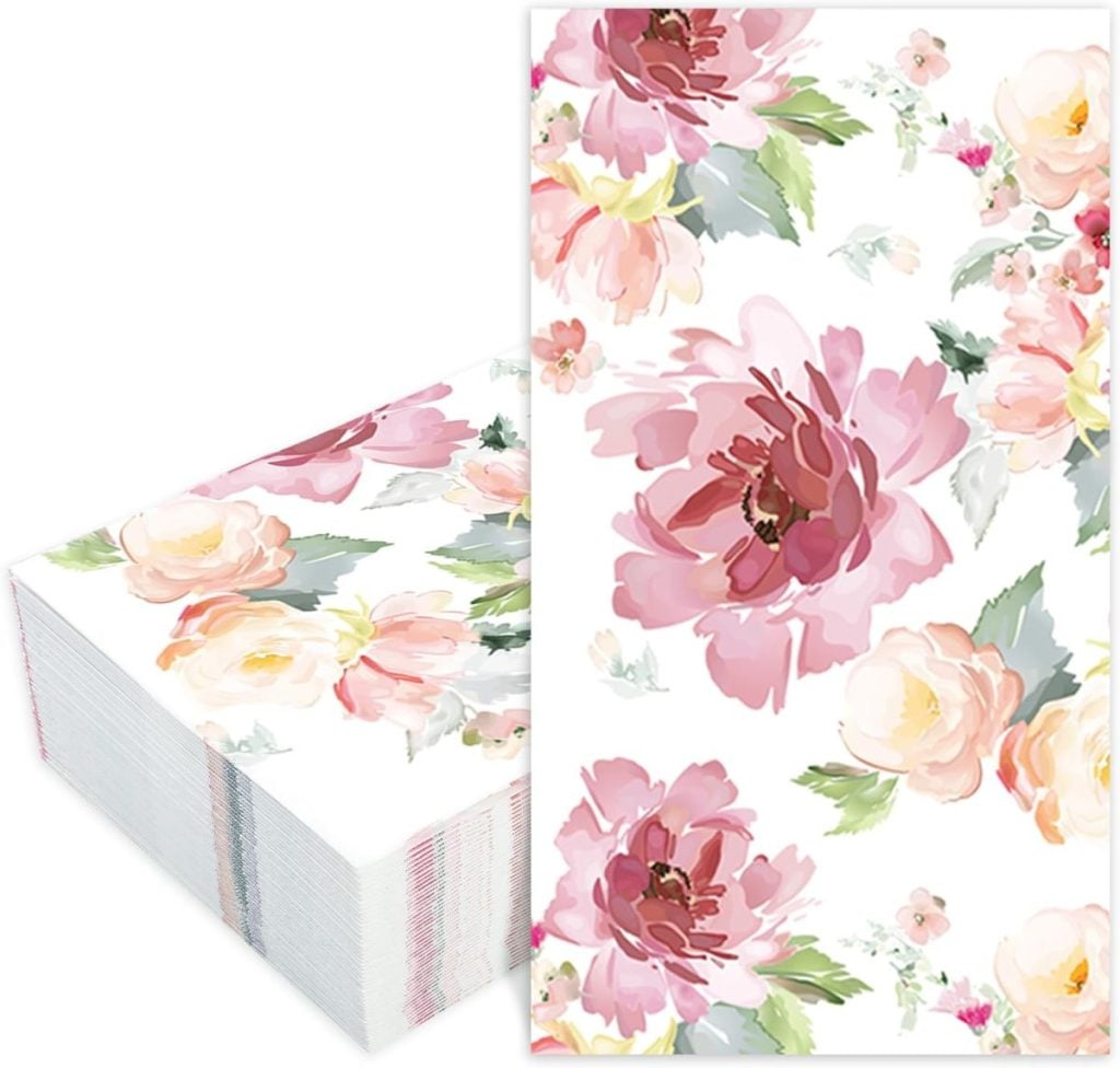 A stack of decorative paper napkins featuring a floral design with pink and peach flowers on a white background.