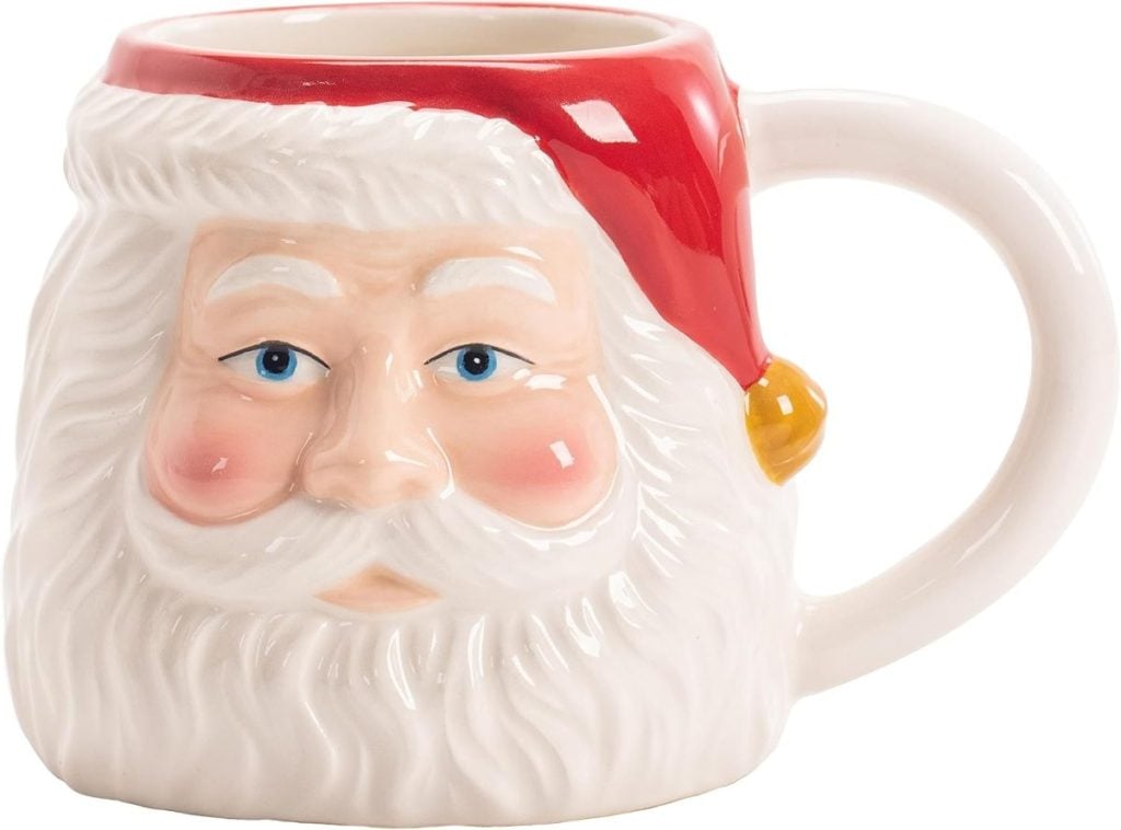 A ceramic mug shaped like Santa Claus's head, featuring a red hat, white beard, and rosy cheeks—perfect for serving hot cocoa alongside your Christmas Eve dinner ideas.