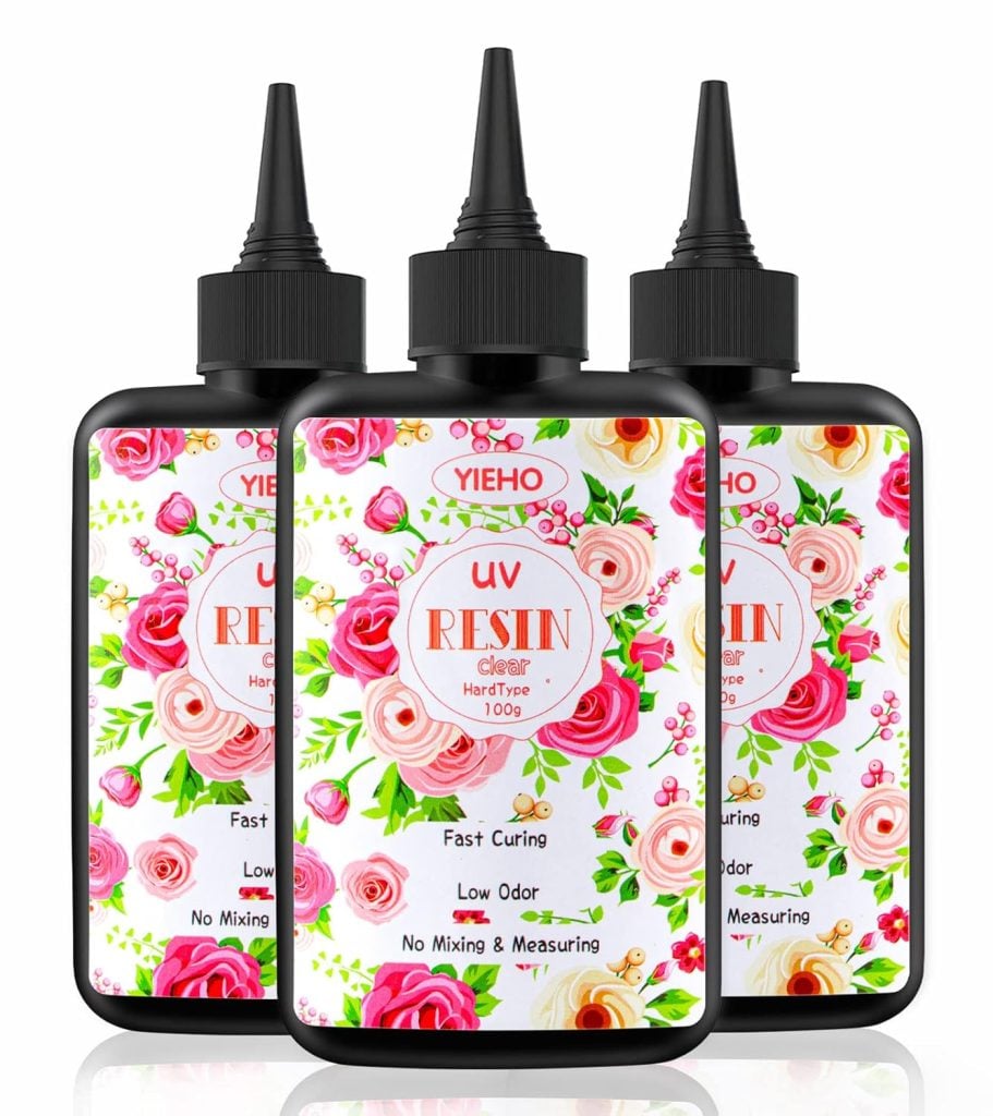 Three bottles of clear UV resin with floral design labels, labeled as fast curing, low odor, no mixing, and measuring.