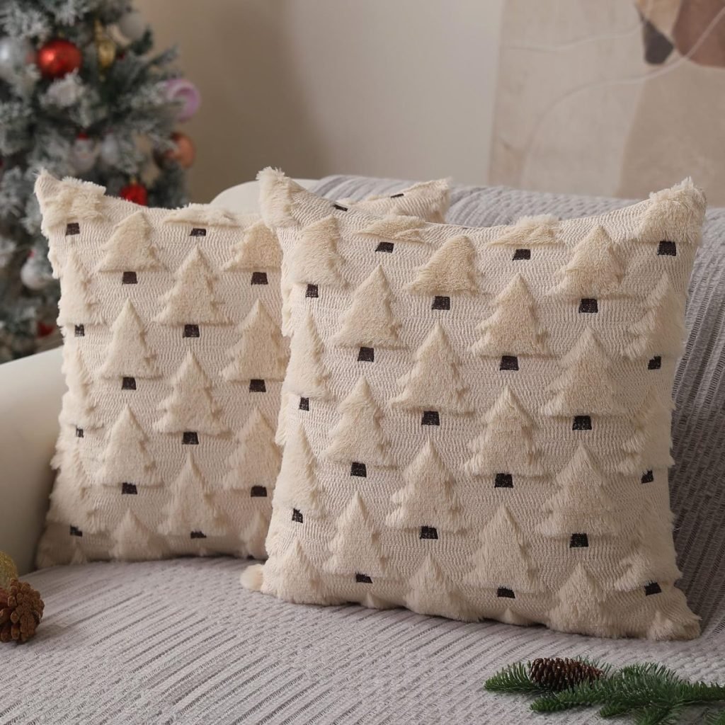 Two beige throw pillows with a tree pattern nestle on a gray sofa, perfectly complementing the festive charm of the Christmas pillow on display, with a decorated Christmas tree shimmering in the background.