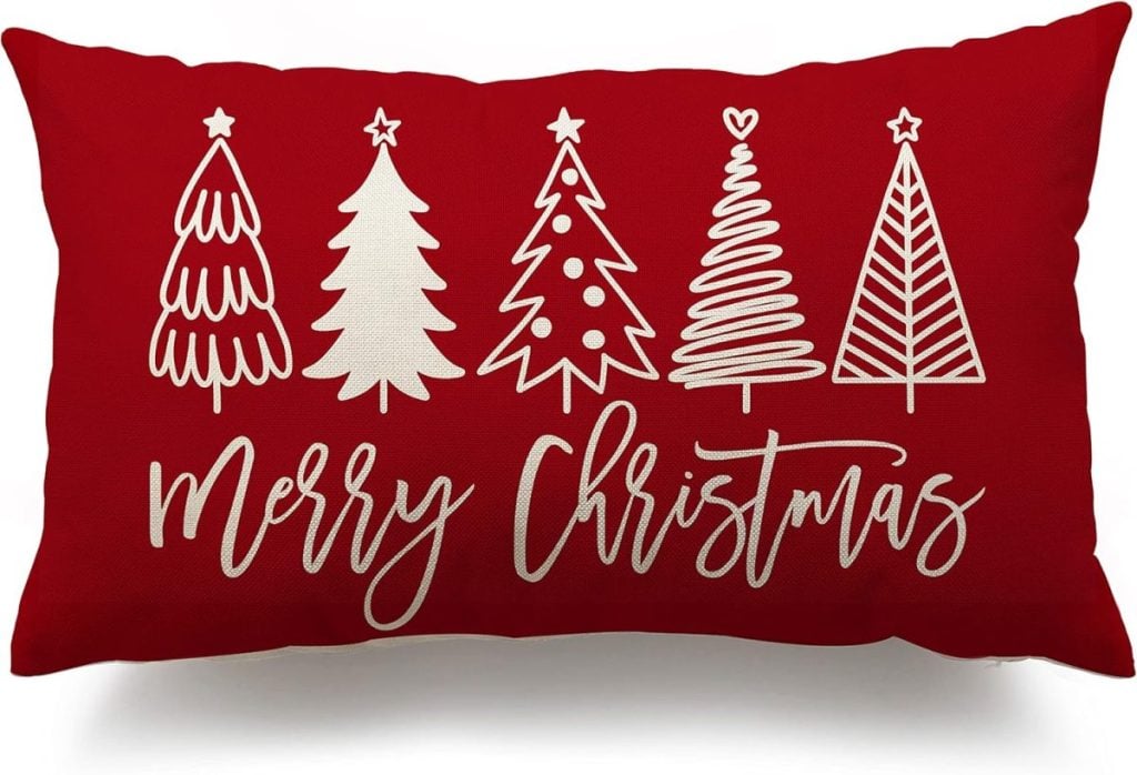 Red rectangular pillow with five white stylized Christmas trees and the words "Merry Christmas" in cursive.