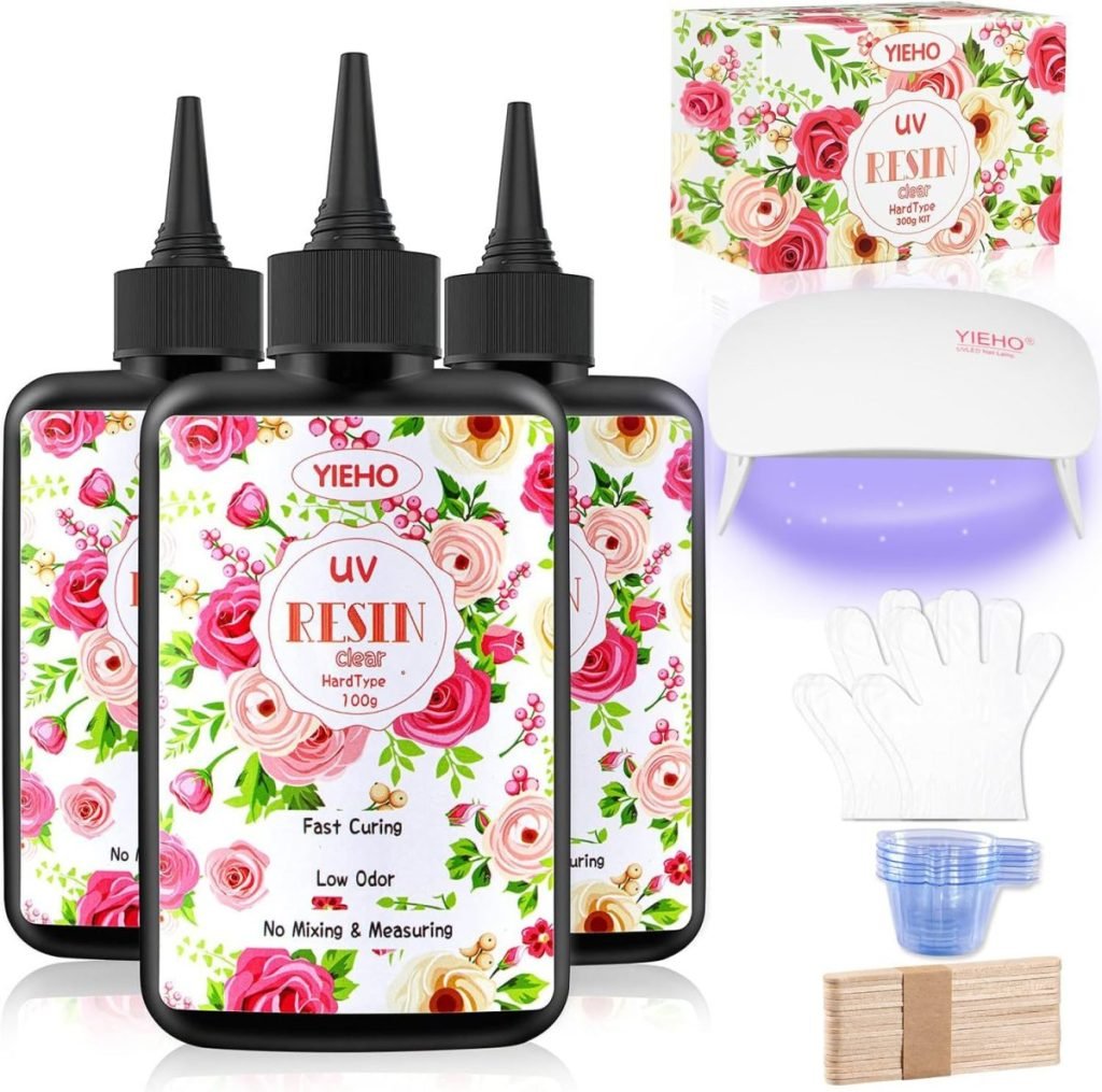 Three bottles of UV resin with floral labels, a UV lamp, disposable gloves, wooden sticks, and a silicone cup.