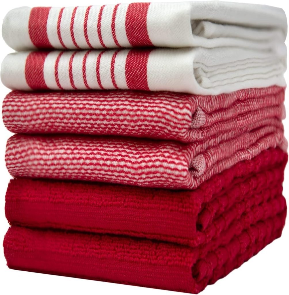 A stack of folded red and white kitchen towels with varying patterns, including stripes and solids.