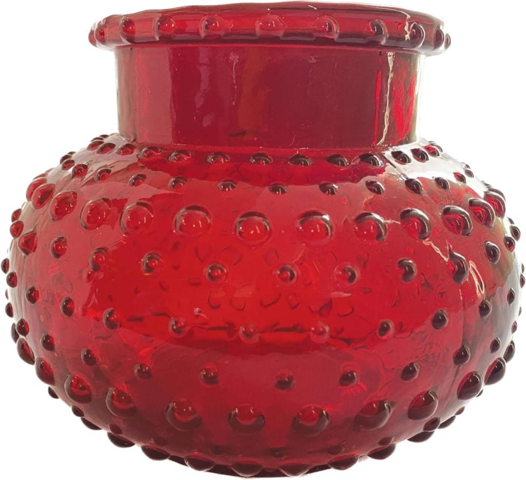 Red glass vase with a wide neck and a textured, dotted surface.