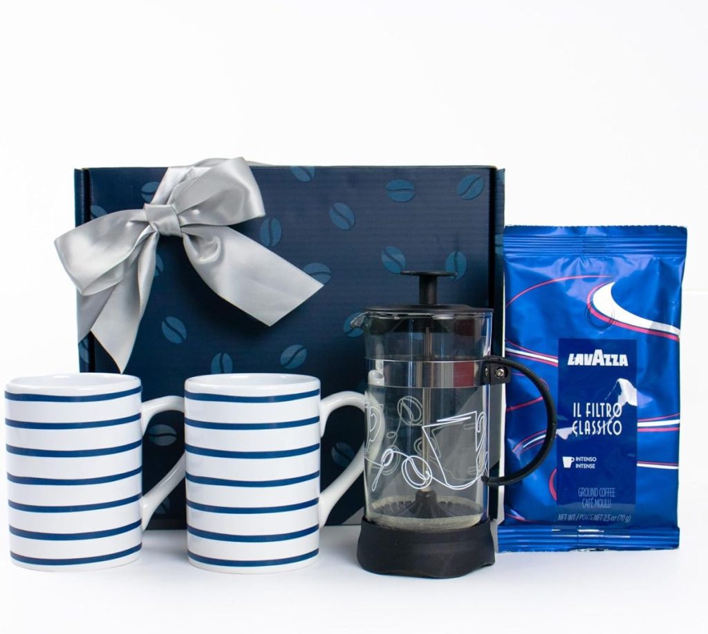 Gift set with two striped mugs, a French press, Lavazza coffee bag, and a blue box with a silver ribbon.