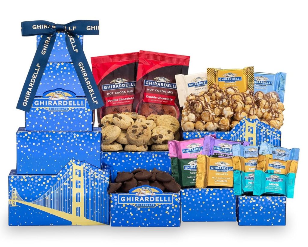 Gift basket featuring Ghirardelli chocolates, cookies, and popcorn. Blue boxes are decorated with a bridge design and tied with a ribbon.