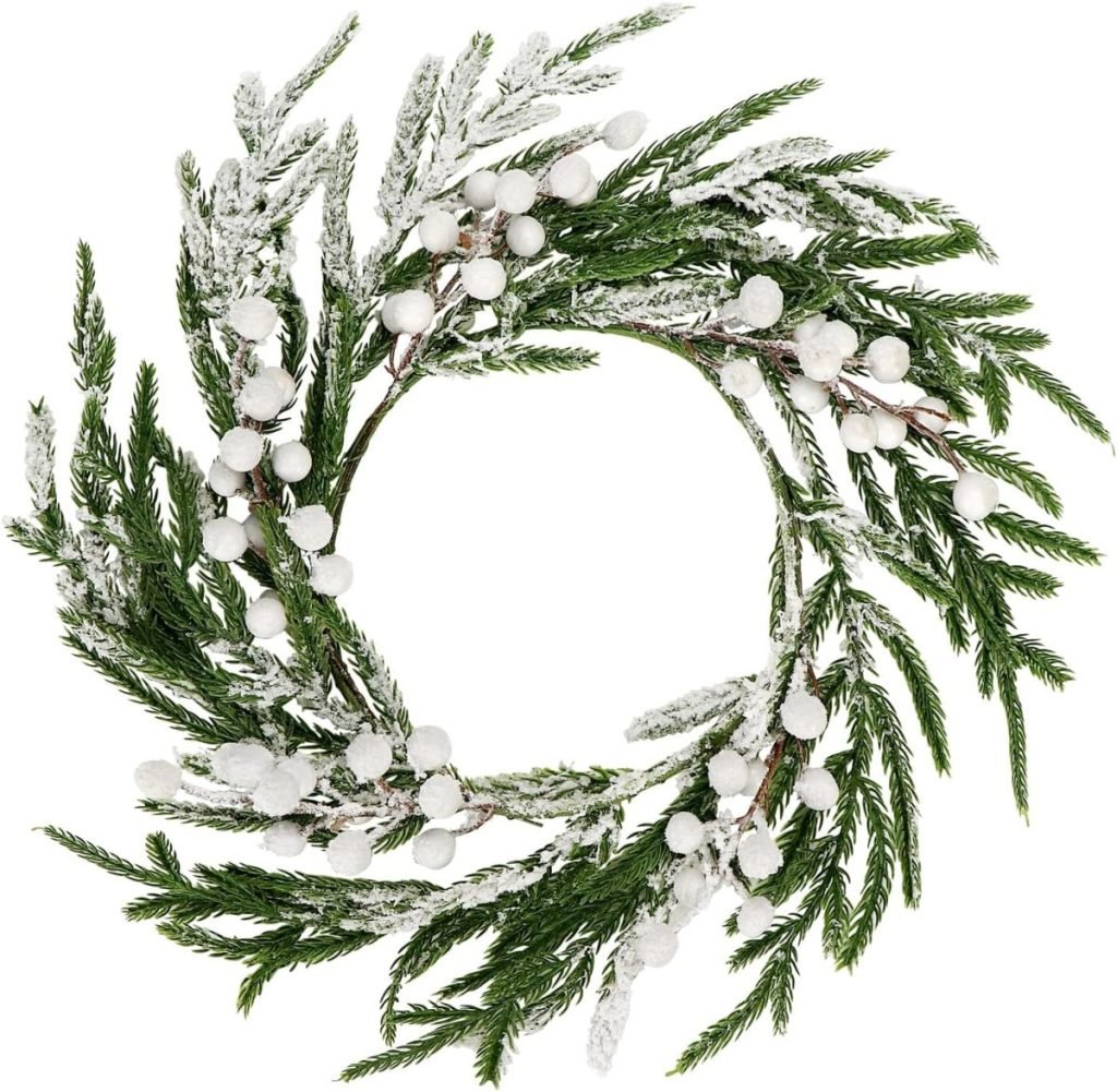 A circular wreath made of frosted evergreen branches and white berries.