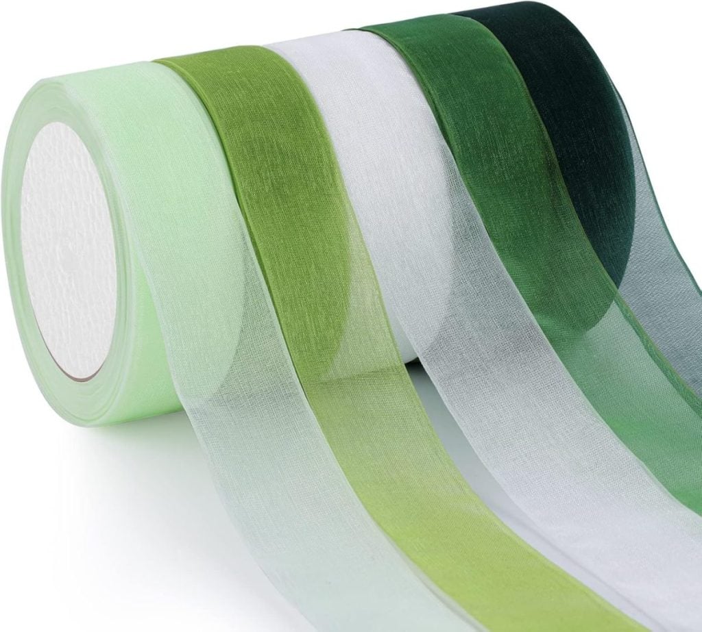 Four rolls of sheer green ribbon in various shades from light to dark, perfect for adding a touch of elegance to your glass Christmas ornaments.