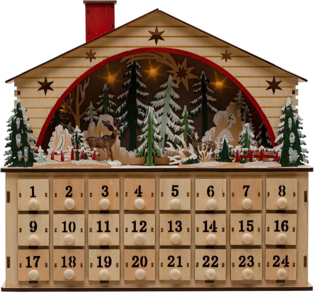 A wooden advent calendar shaped like a house with 24 numbered drawers, decorated with trees, reindeer, and a snowy forest scene—perfect to display Christmas cards alongside your holiday decor.