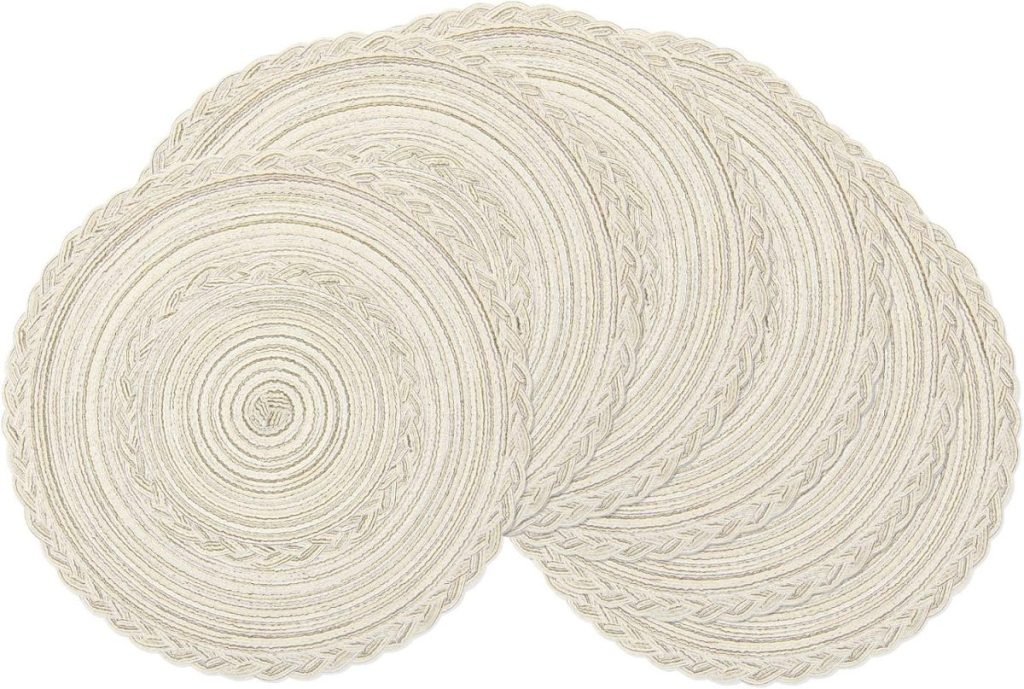 Four round, braided, off-white placemats are overlapping each other on a plain white background, creating a simple yet elegant setting perfect for displaying clay ornaments.