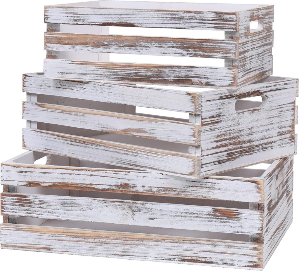 Three stacked wooden crates with a weathered white finish and cutout handles.