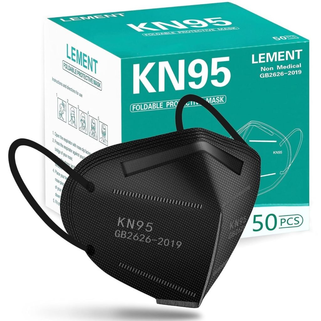 A black KN95 mask sits elegantly in front of a box labeled "KN95 Lement Foldable Protective Mask, Non-Medical, 50 PCS, GB2626-2019," almost like a piece from a collection of finely crafted clay ornaments.