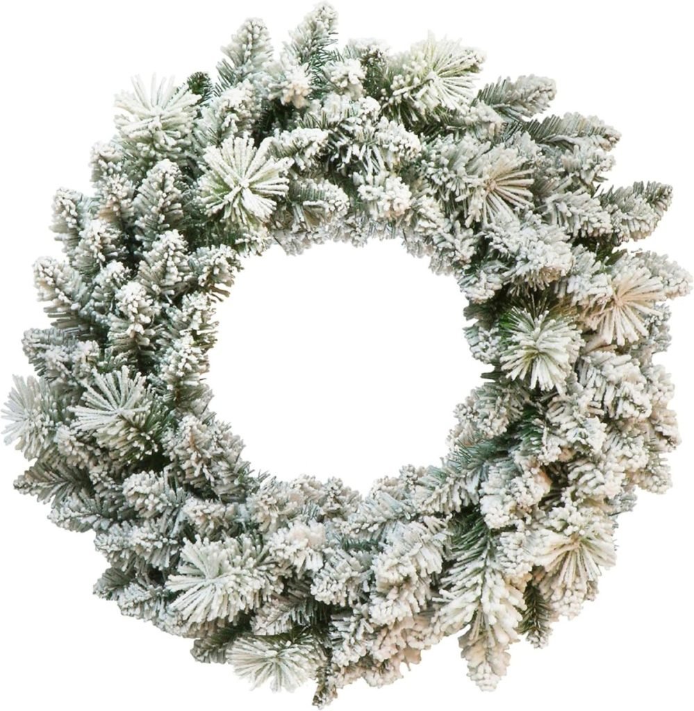 Snow-covered evergreen wreath with frosted branches, arranged in a circular shape.