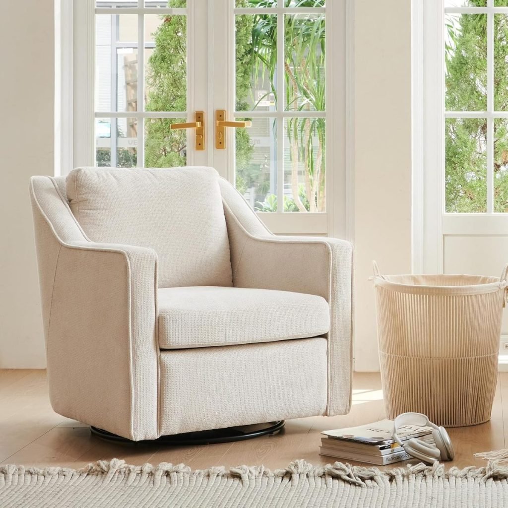 A beige armchair is placed on a light wood floor near a window. A woven basket and books are on the floor nearby.