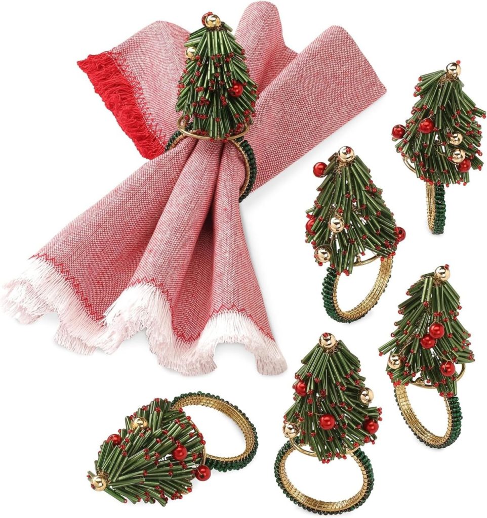 Six Christmas tree-shaped napkin rings with red and gold decorations are displayed, one holding a red and white napkin—perfect for adding festive charm to your Christmas dinner table.