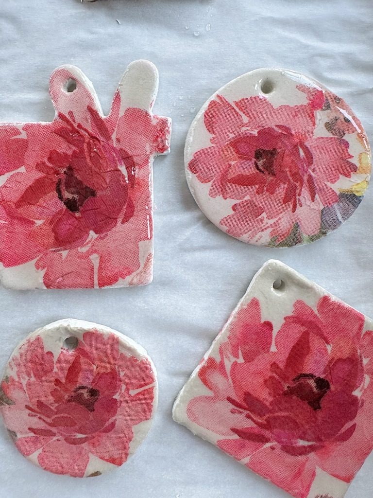 Four decorative clay shapes with red and pink floral designs.