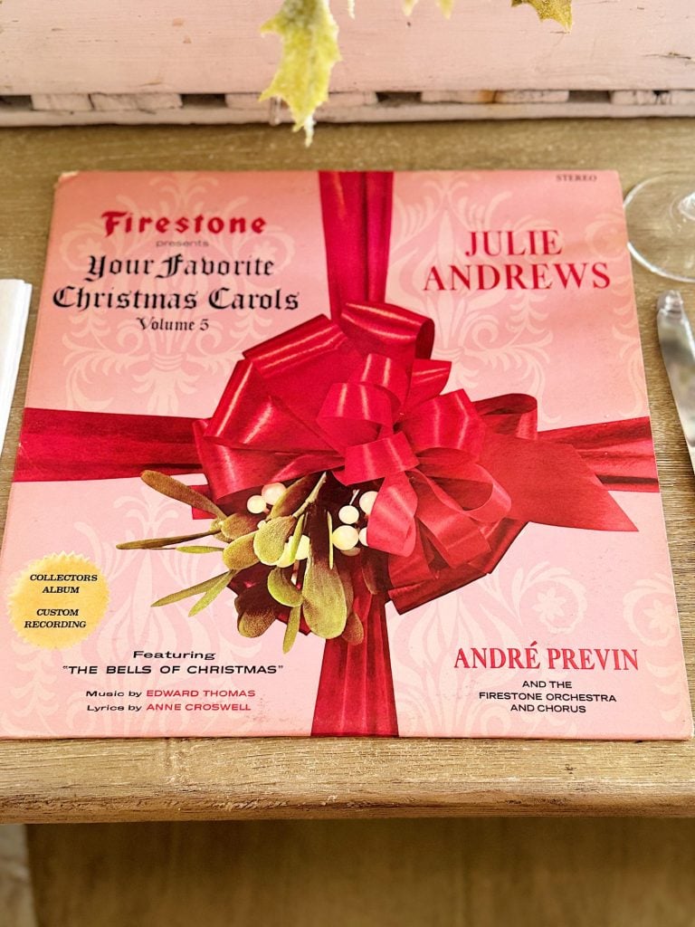 Vinyl record of "Your Favorite Christmas Carols Volume 5," featuring Julie Andrews and André Previn, wrapped in a red ribbon with a mistletoe decoration.