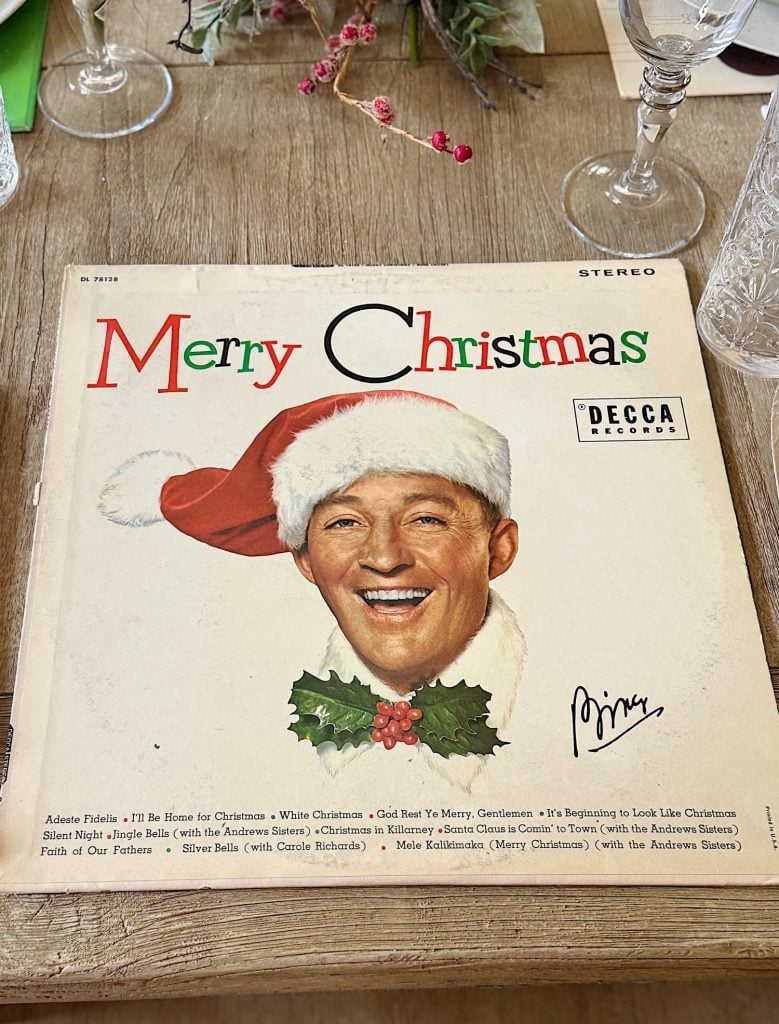 Album cover of "Merry Christmas" by Bing Crosby, featuring a smiling man in a Santa hat.