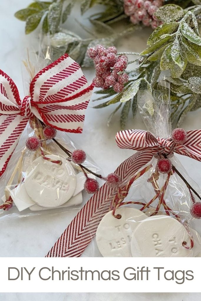 Two clear bags with red and white striped ribbons and clay gift tags, set against a green and red berry branch. Text reads: "DIY Christmas Gift Tags.