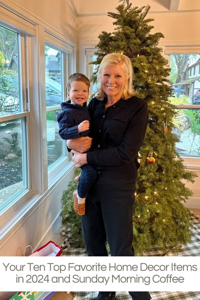 Woman holding a child stands in front of a decorated Christmas tree.