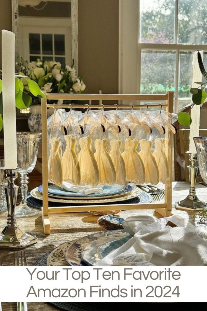 Table setting with decorated cookies shaped like female figures on a rack, surrounded by plates, silverware, and candles. Text reads, "Your Top Ten Favorite Amazon Finds in 2024.